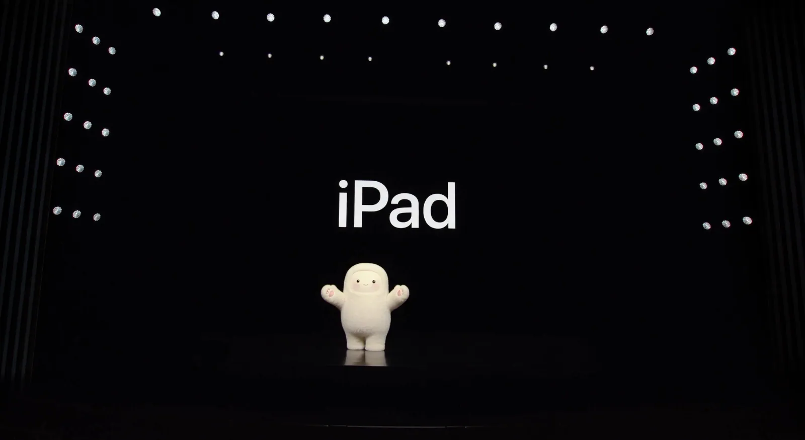 Jolly, the Muse mascot, presenting on a black keynote stage under the word iPad